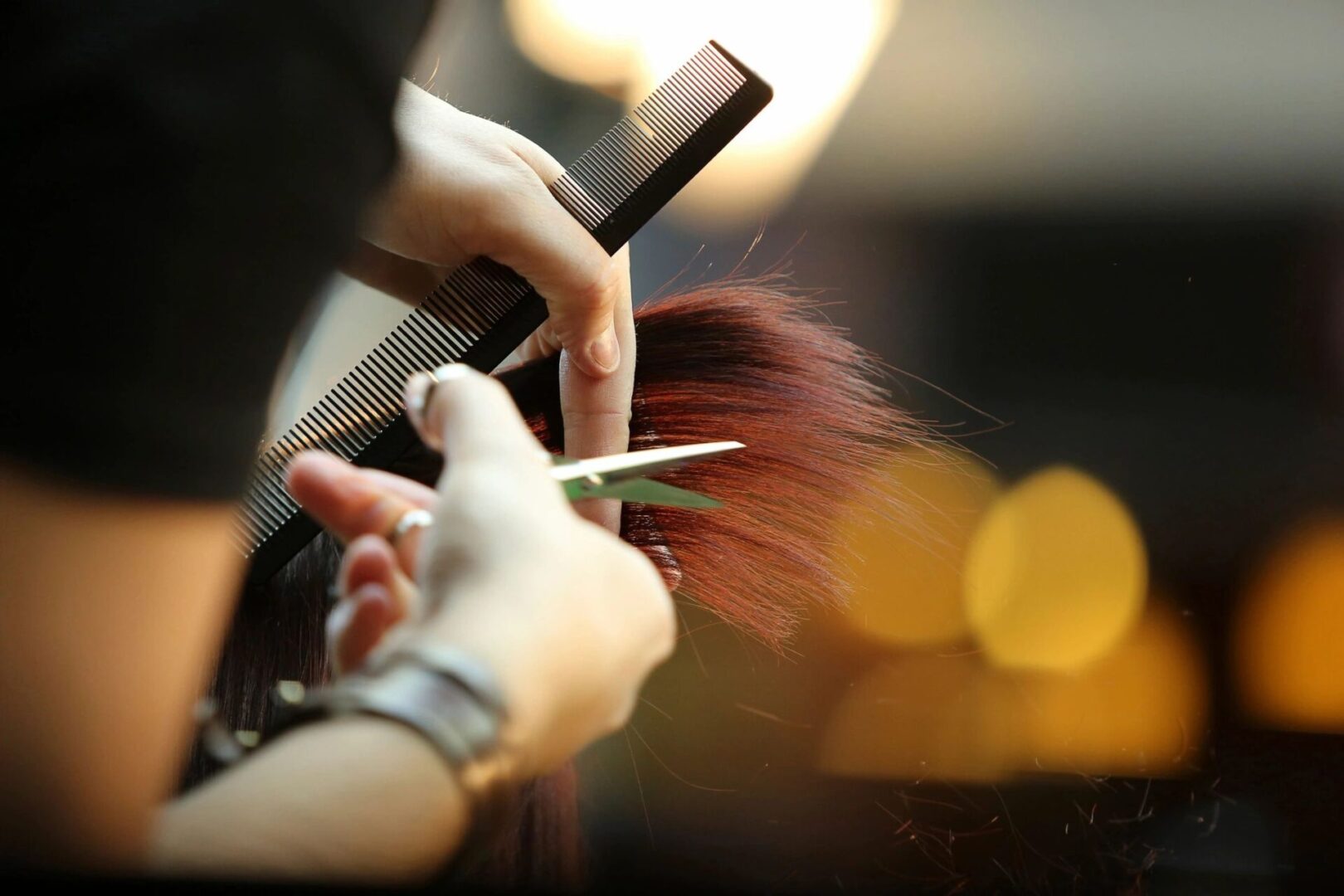 A person cutting their hair with scissors.